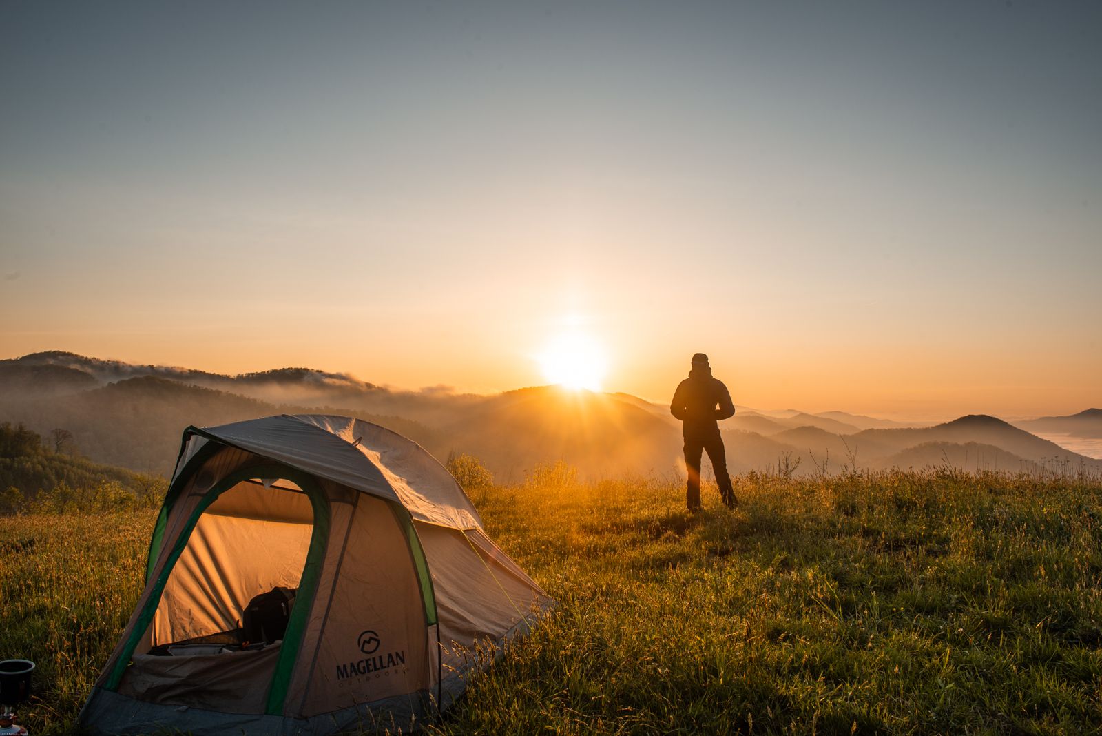 Camping tent set up outdoors near a campsite with gear packed for a multi-day trip