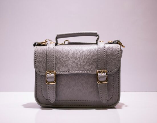 Grey leather satchel with gold hardware showing everyday handbag materials and durability