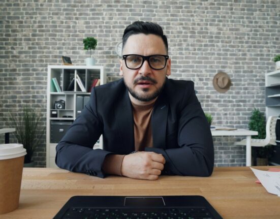 Professional at a laptop using a 1080p webcam for video meetings in Canada