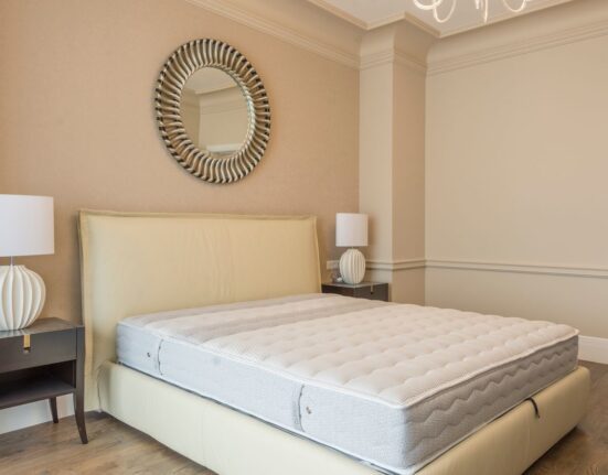 Neatly made bed in a bright bedroom for choosing mattress firmness