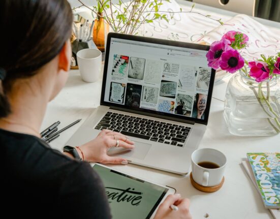 Person designing a website on a laptop while choosing a WordPress theme for an online store
