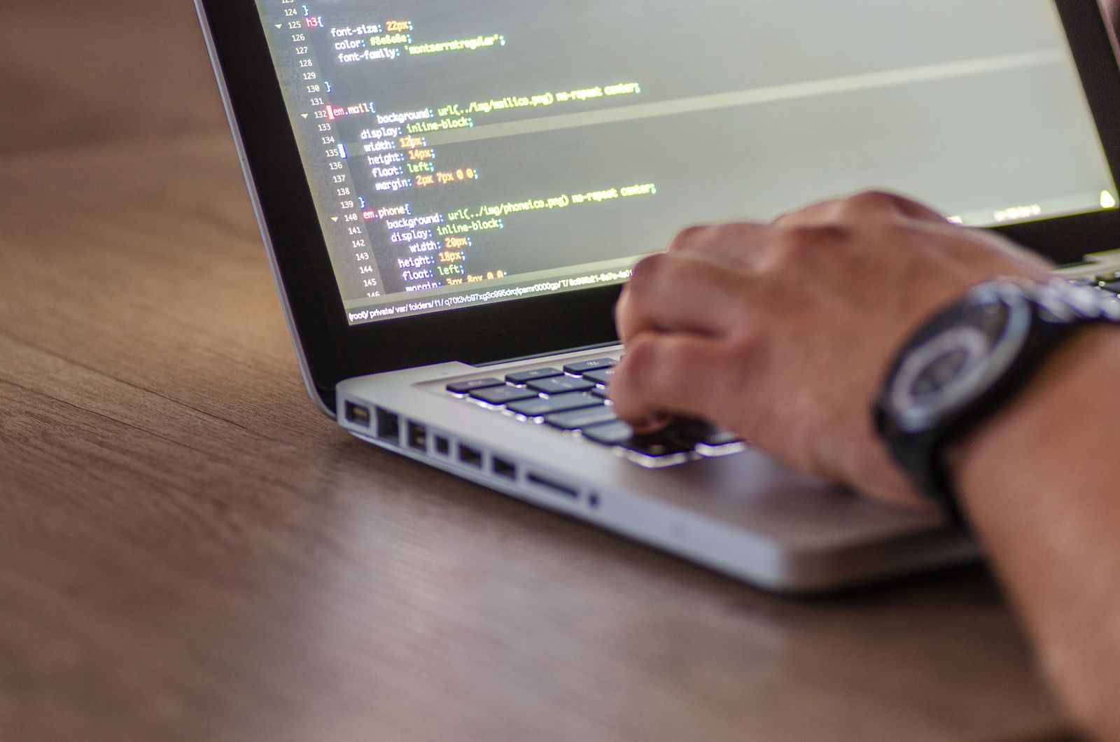Hands typing on a laptop while reviewing a bulk delete email checklist