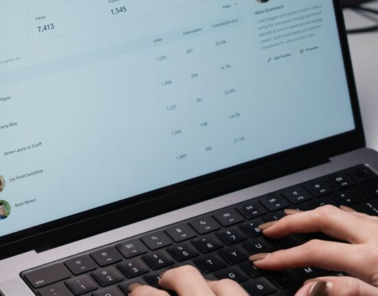 Person typing on a laptop while choosing an email inbox organizer