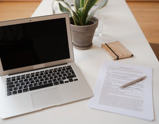 Laptop and documents on a desk used to evaluate a software lifetime deal