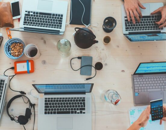Team working on laptops comparing free AI video generator limits in Canada
