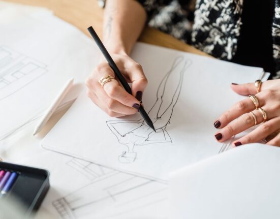Designer sketching on paper while working on a freelance logo design project