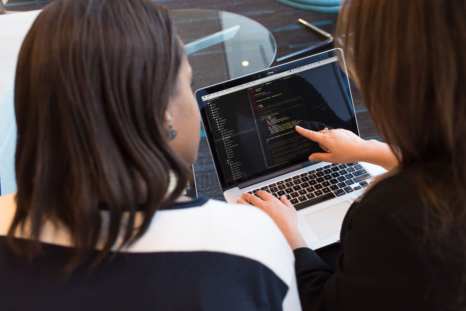 Two colleagues reviewing multi device antivirus coverage on a laptop