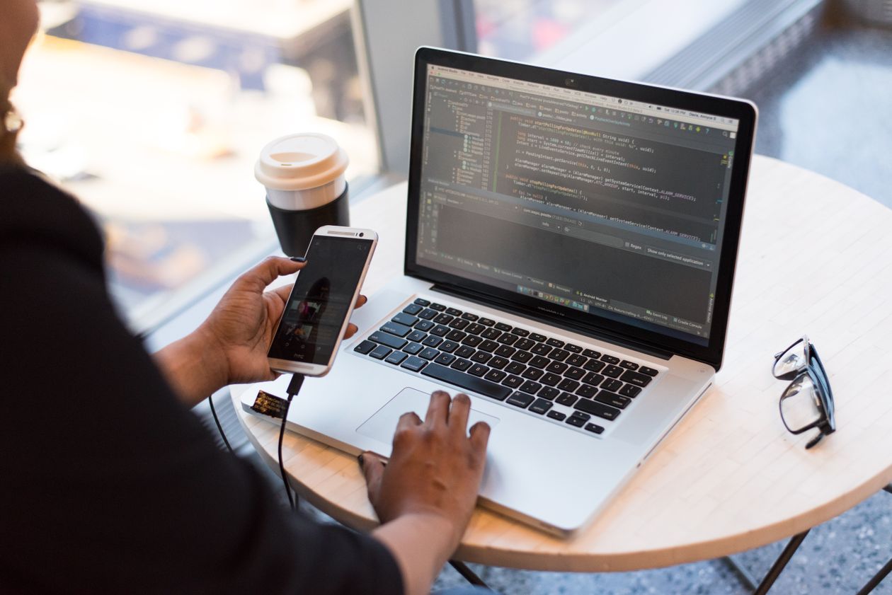 Laptop and smartphone on a table showing security suite feature comparison in Canada
