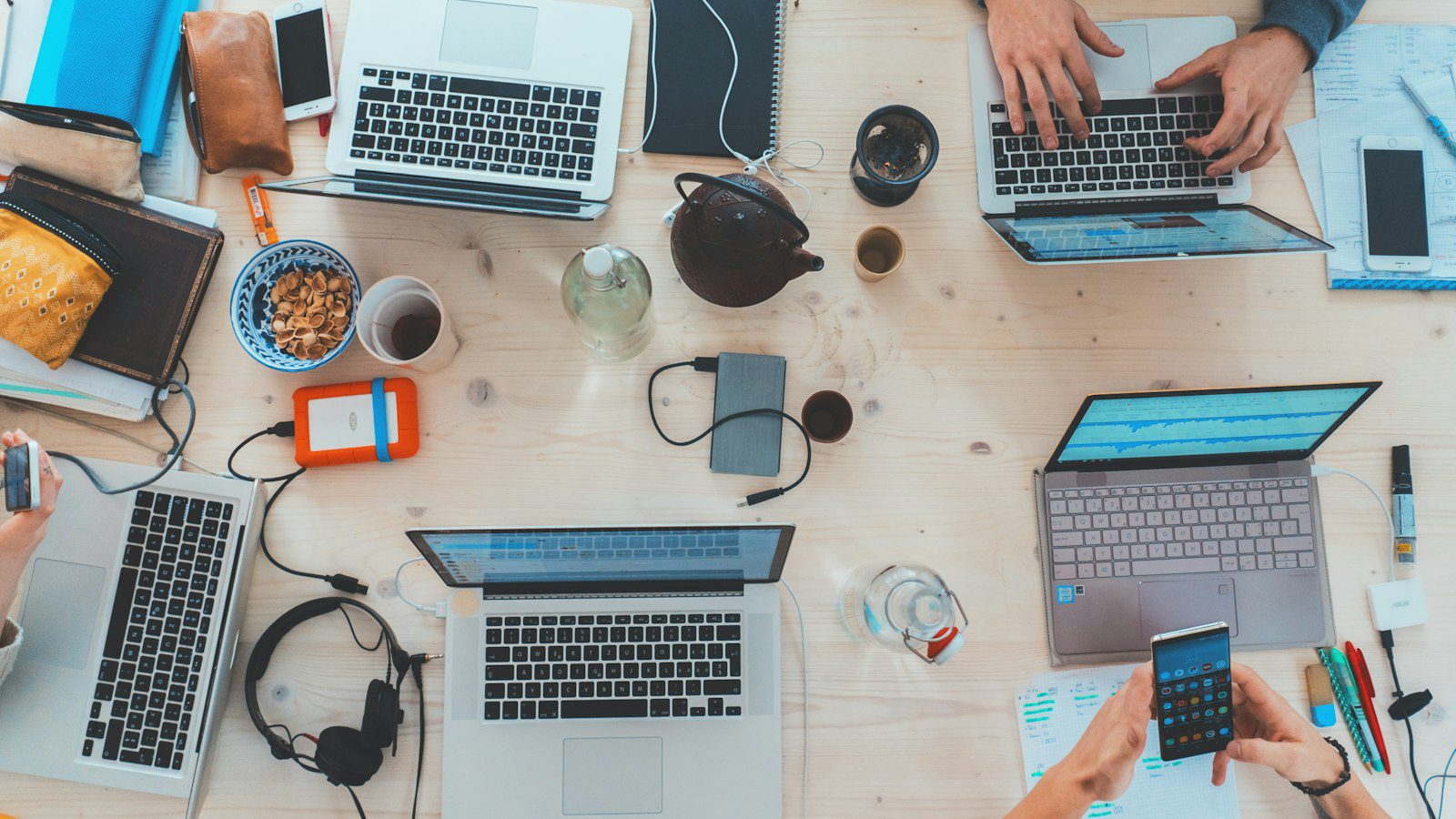 Colleagues at a table with laptops reviewing shared AI workspace features