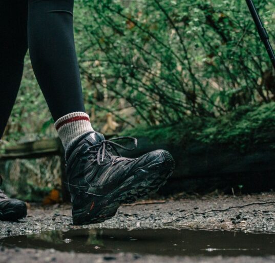 Hiker wearing waterproof hiking boots on a rocky trail